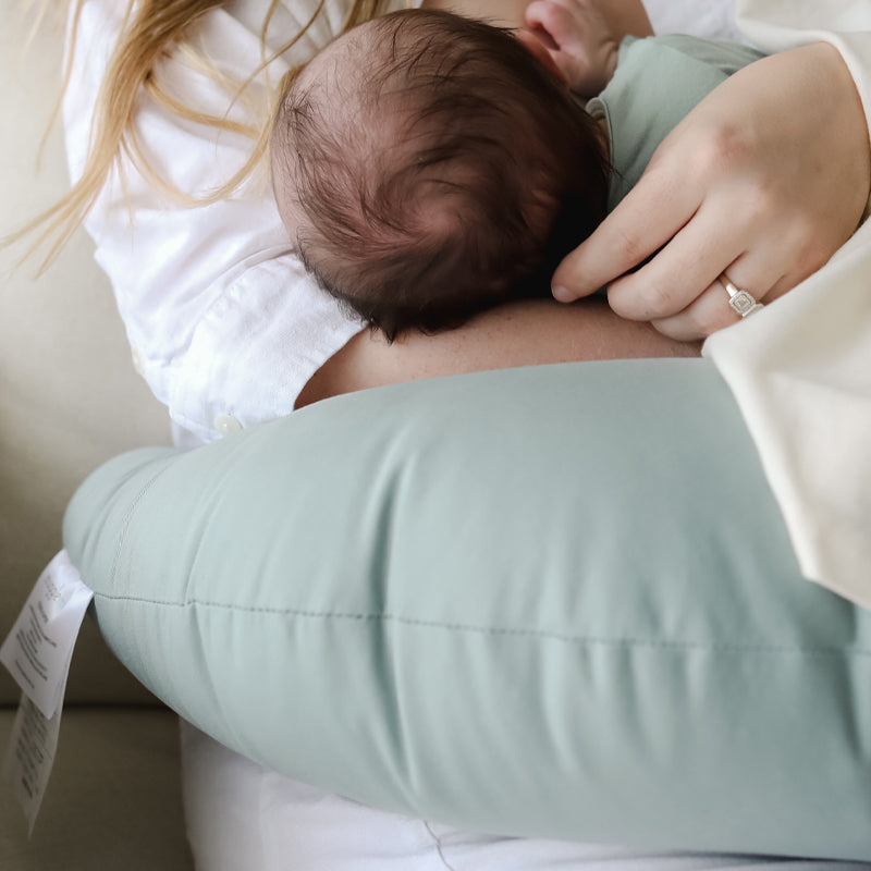 newborn baby breastfeeding on snuggle me organic feeding support nursing pillow in slate