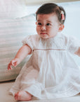 baby elsie wearing purebaby organic embroidered dress vanilla special occasion organic cotton clothes