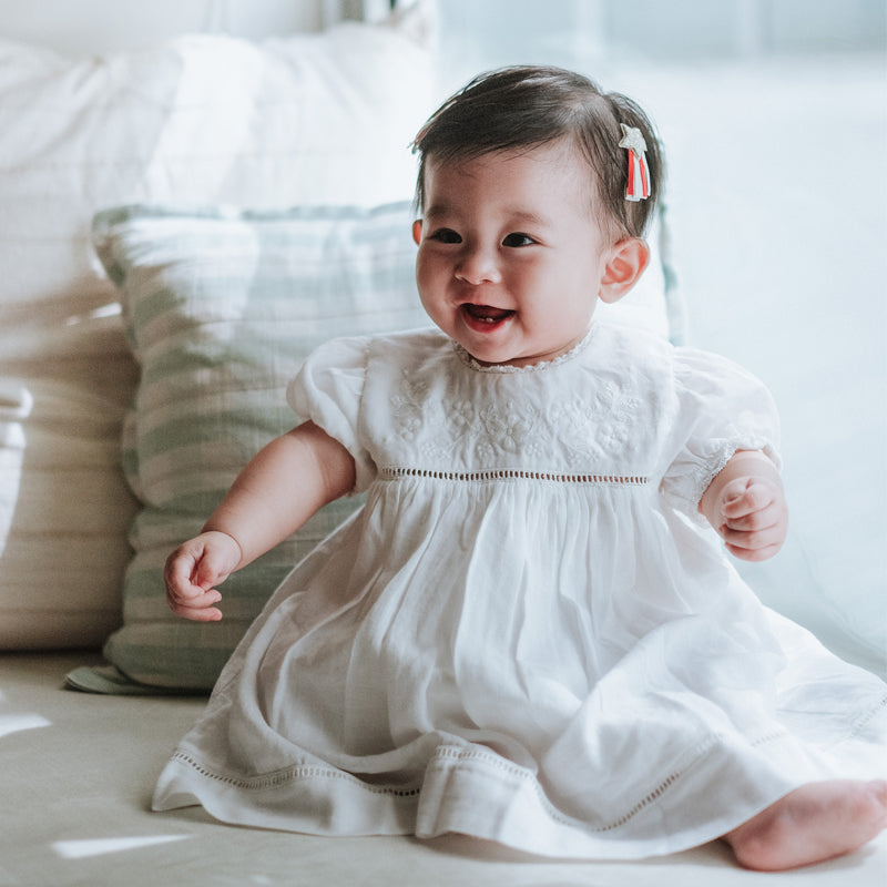 baby elsie wearing purebaby organic embroidered dress vanilla special occasion organic cotton clothes