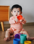 baby elsie wearing purebaby organic red coral gingham baby swimwear