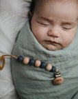 baby in mushie organic muslin swaddle blanket newborn