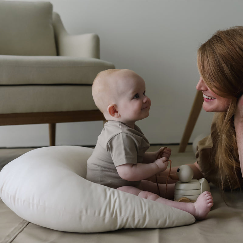 baby sitting up on snuggle me organic feeding support pillow